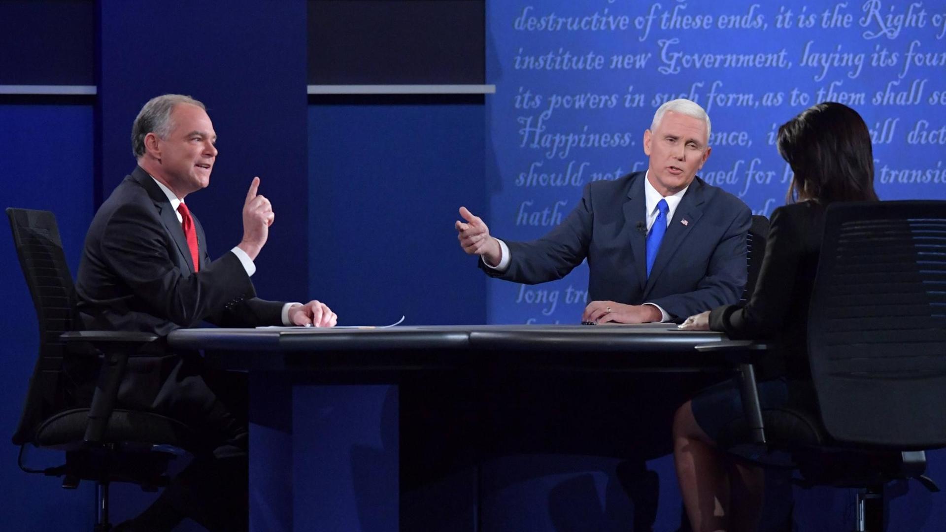 Mike Pence und Tim Kaine sitzen an einem Tisch und debattieren
