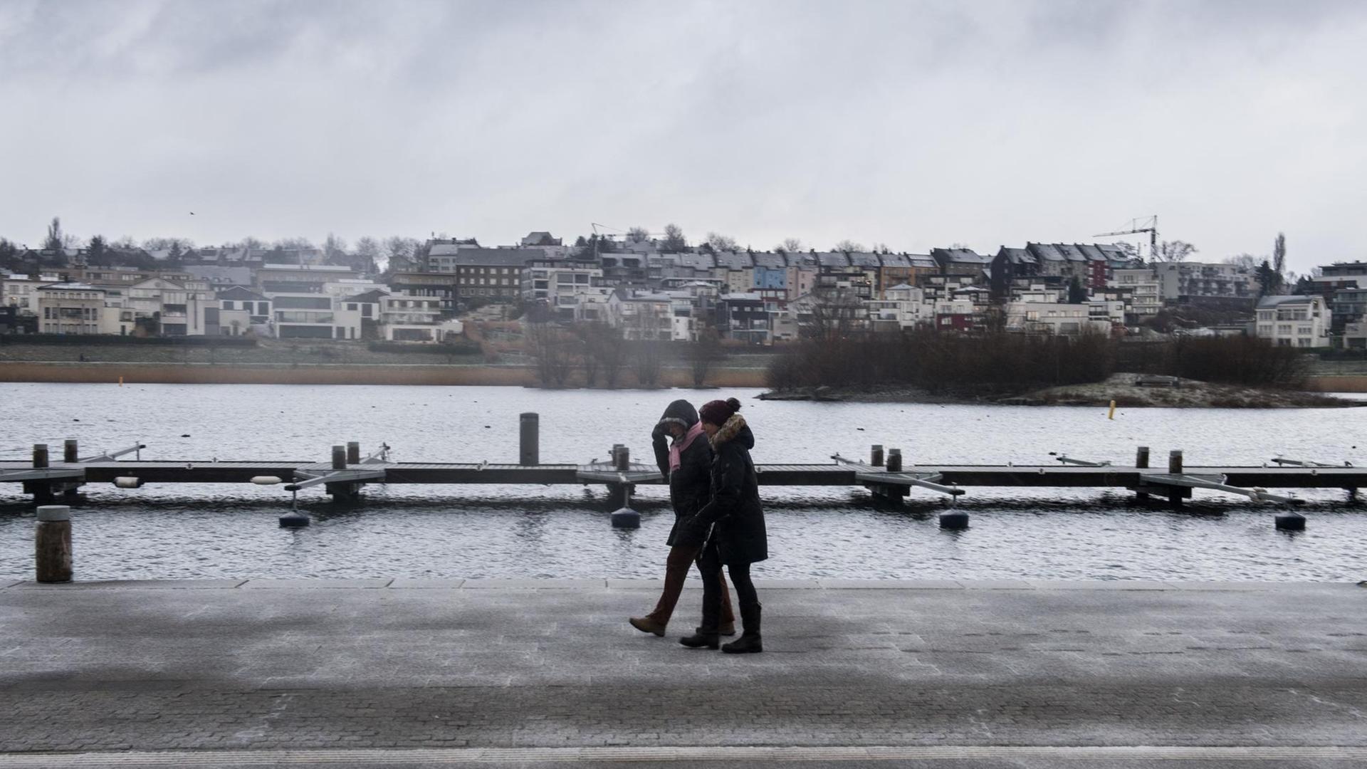 Zwei Frauen gehen bei nass-kaltem Wetter am Ufer des Phoenix Sees in Dortmund (Nordrhein-Westfalen) spazieren.