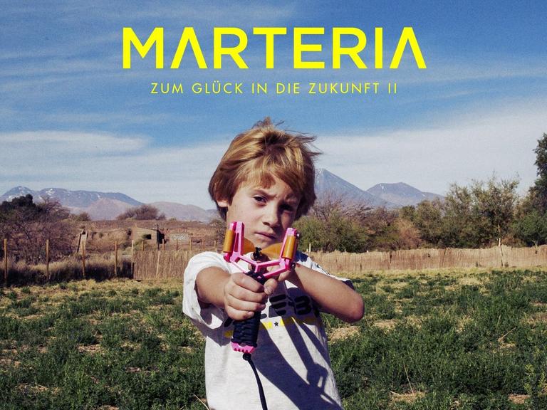Auf dem Cover "Zum Glück in die Zukunft II" von Marteria spannt ein Junge auf einer Wiese eine Schleuder und zielt auf den Betrachter.