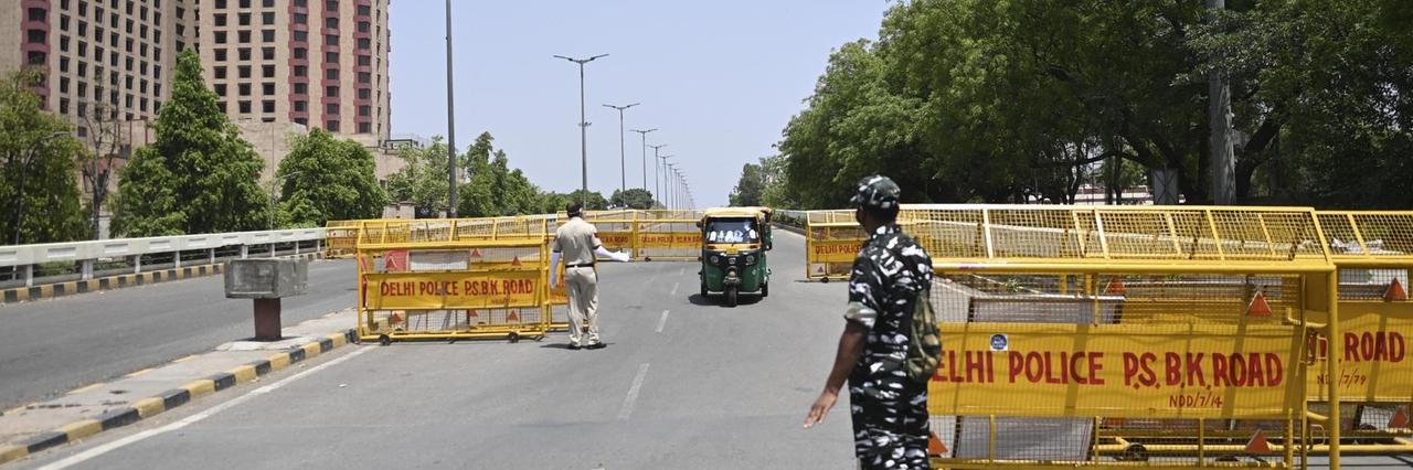 Bewaffnete Sicherheitskräfte kontrollieren Fahrzeuge an einer Straßensperre in Delhi