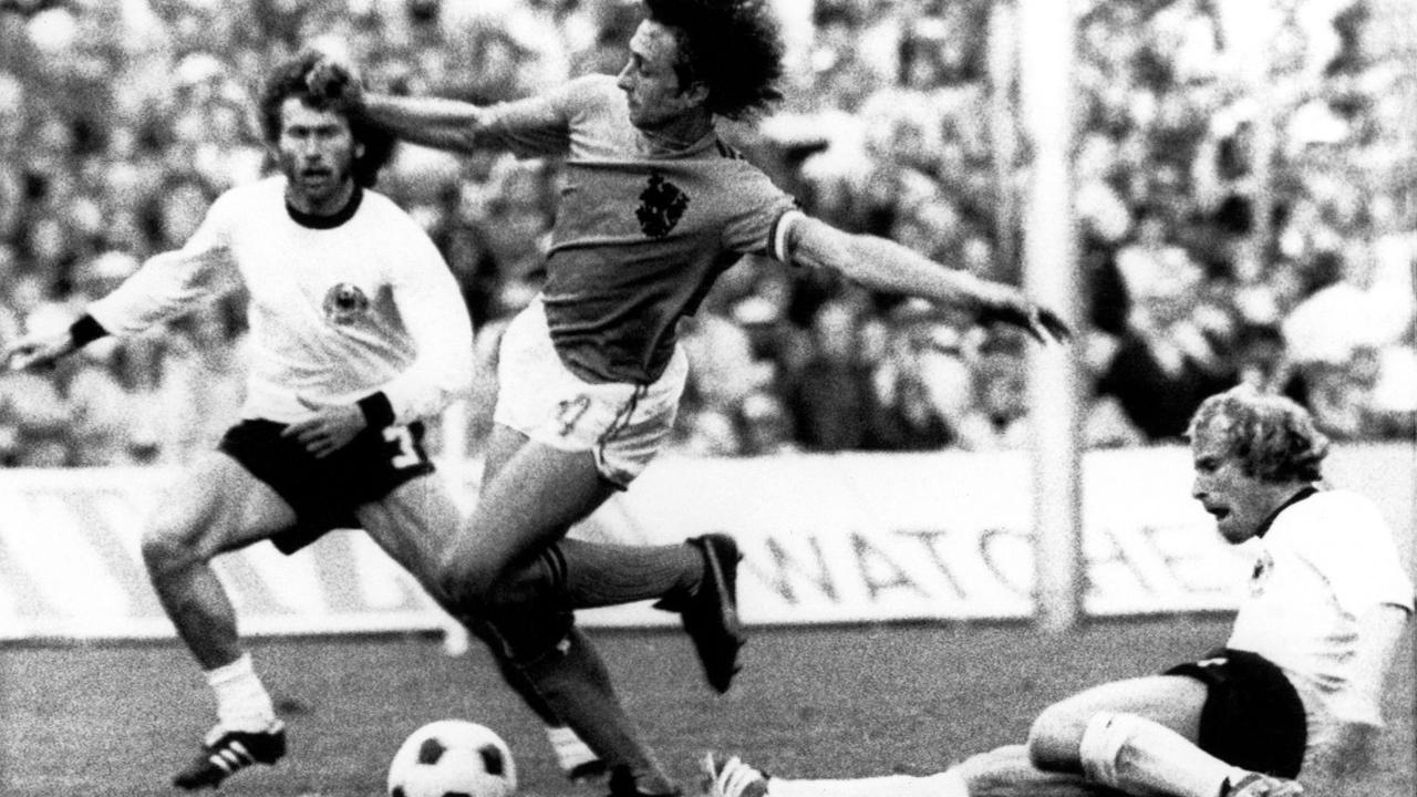 Der niederländische Fußballer Johan Cruyff (m.) spielte im WM-Finale 1974 unter anderem gegen Paul Breitner (r.) und Berti Vogts (r.)