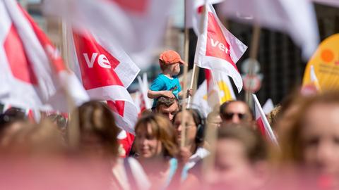 Beschäftigte kommunaler Kinderbetreuungseinrichtungen und ein kleiner Junge nehmen am 11.05.2015 in München an der Demonstration zum Kita-Warnstreik in Bayern teil und halten Verdi-Flaggen in die Luft