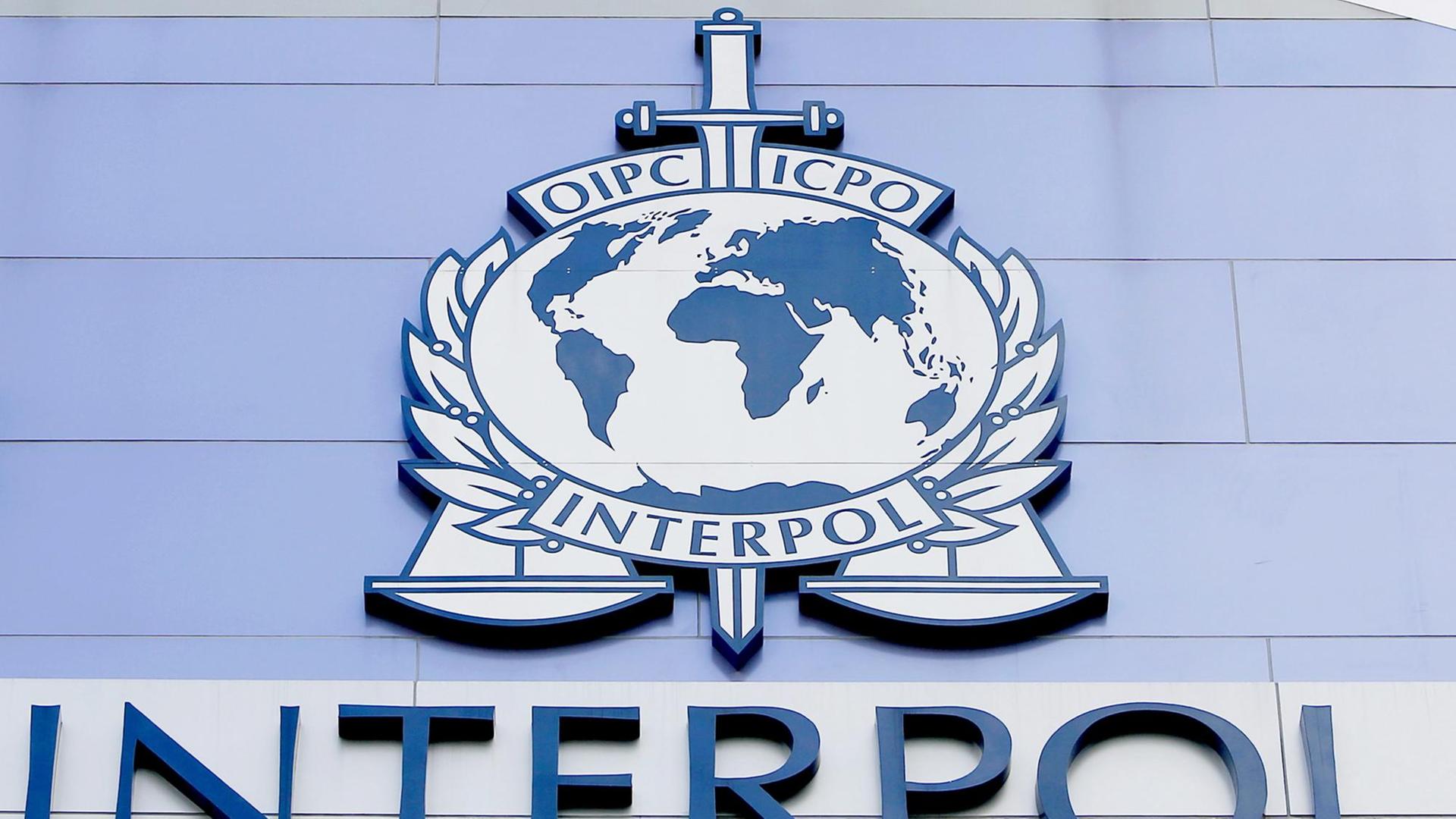 Das Interpol-Logo auf einer Wand Das Interpol-Logo auf einer Wand