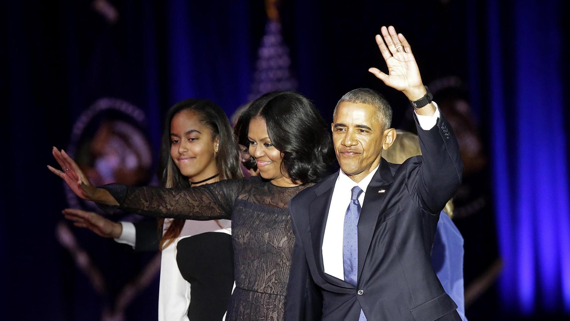 US-Präsident Barack Obama und seine Frau Michelle winken mehreren tausend Anhängern in Chicago zu. Im Hintergrund ist eine Tochter zusehen.