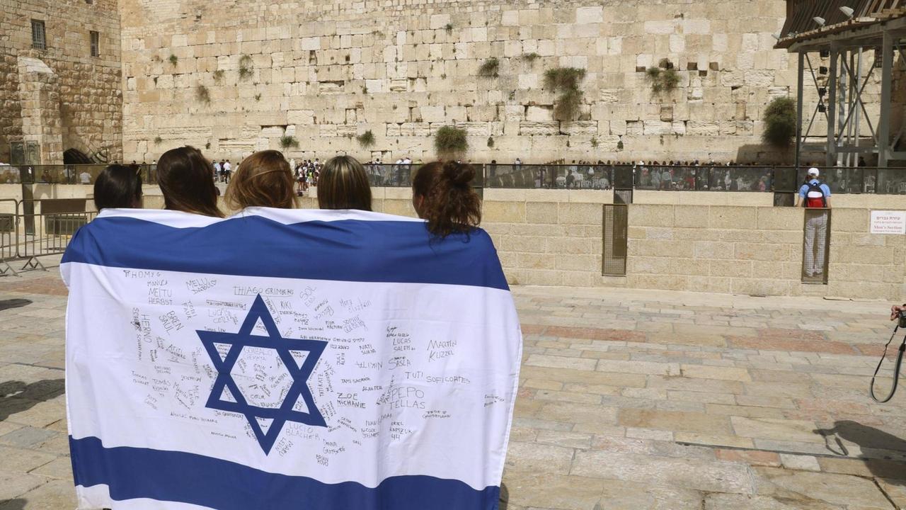 Junge Menschen stehen wegen des 70. Gründungsjubiläums mit einer Israel-Fahne in der Altstadt von Jerusalem.