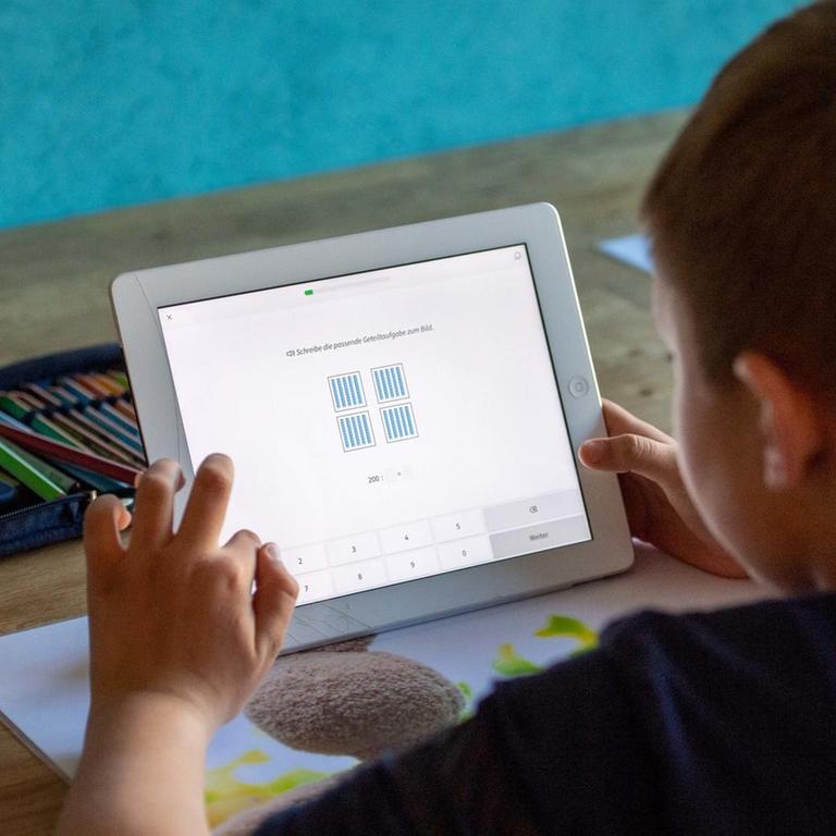 Joel loest zu Hause seine Schulaufgaben am Ipad, Tablett PC, Computer, digital, Lernen in der Coronakrise, am 25.03.2020 bei Ahlen/ Deutschland. | Verwendung weltweit
