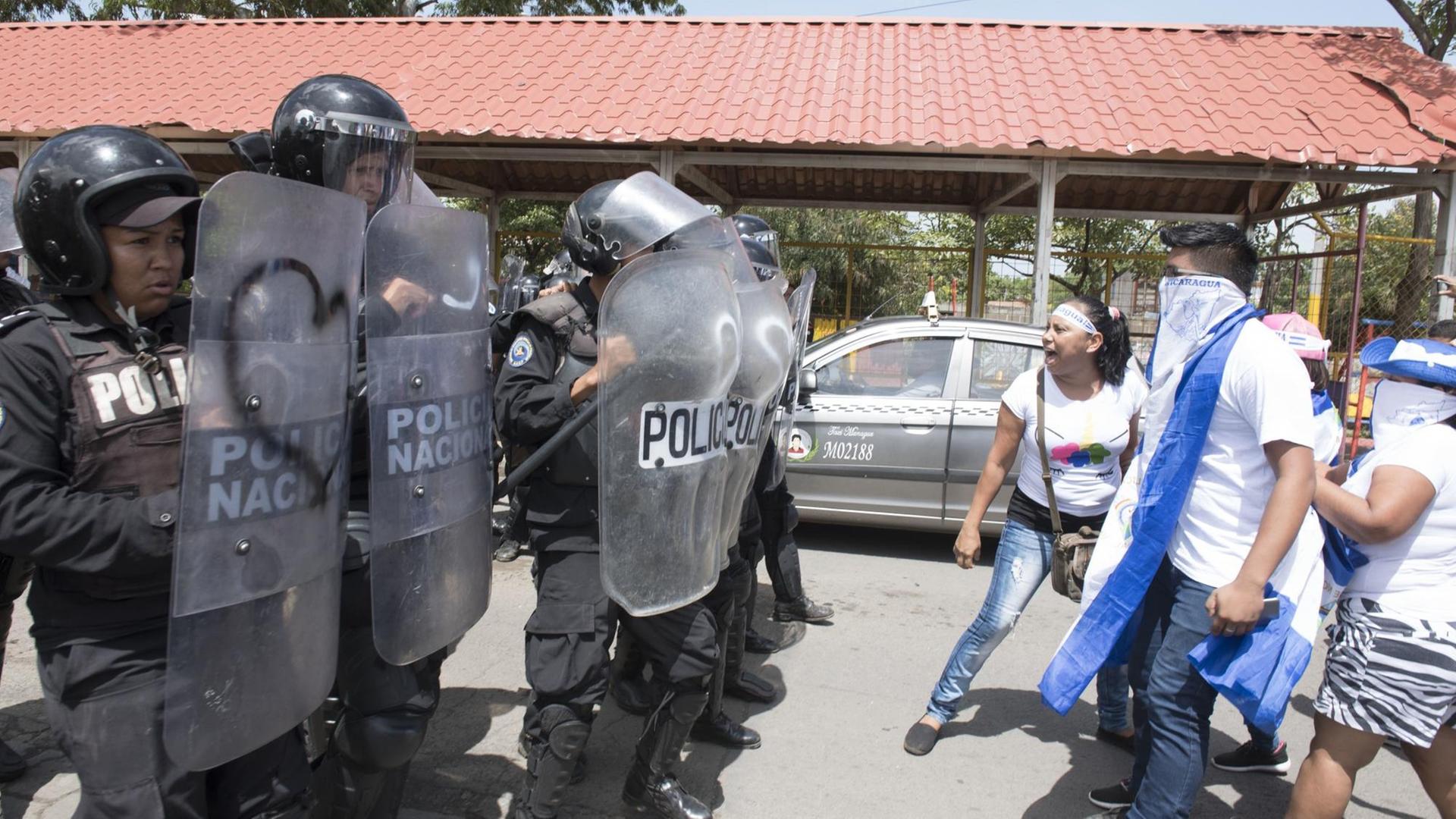 Bereitschaftspolizisten und Demonstranten stehen sich in Managua gegenüber