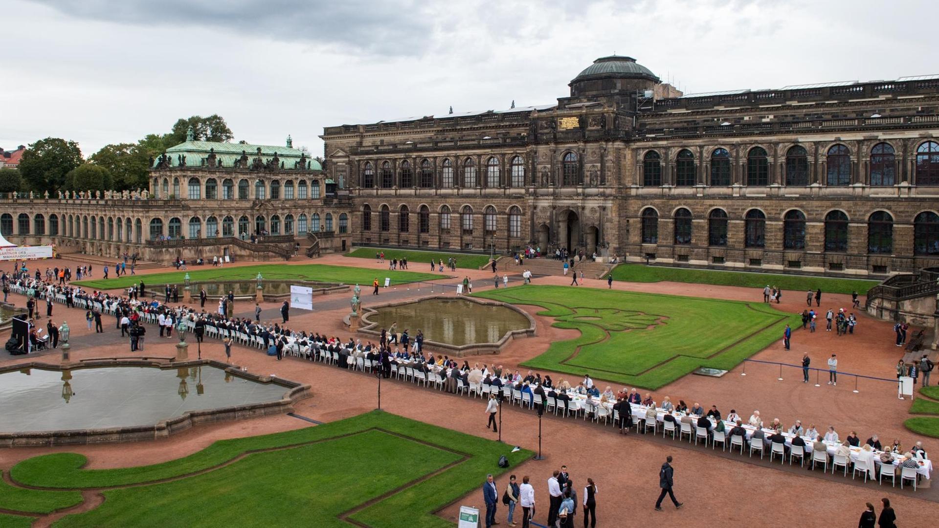 Mitglieder der Bürgerdelegationen aus allen 16 Bundesländern haben im Rahmen des Bürgerfestes an einer 100 Meter langen Kaffeetafel im Zwinger in Dresden Platz genommen. Anlässlich der Feierlichkeiten zum Tag der Deutschen Einheit findet in der Landeshauptstadt bis 03. Oktober ein Bürgerfest statt. Foto: dpa / Arno Burgi Mitglieder der Bürgerdelegationen aus allen 16 Bundesländern haben im Rahmen des Bürgerfestes an einer 100 Meter langen Kaffeetafel im Zwinger in Dresden Platz genommen. Anlässlich der Feierlichkeiten zum Tag der Deutschen Einheit findet in der Landeshauptstadt bis 03. Oktober ein Bürgerfest statt. Foto: dpa / Arno Burgi