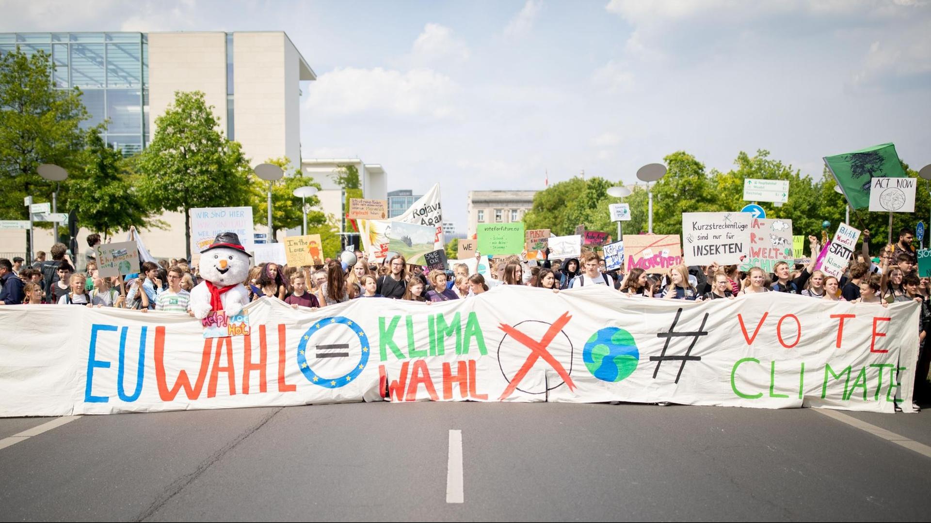 Im Vordergrund Schülerinnen und Schüler die einen großen Banner mit der Aufschrift "EU Wahl gleich Klimawahl" tragen. Im Hintergrund unzählige Schülerinnen und Schüler mit Transparenten.