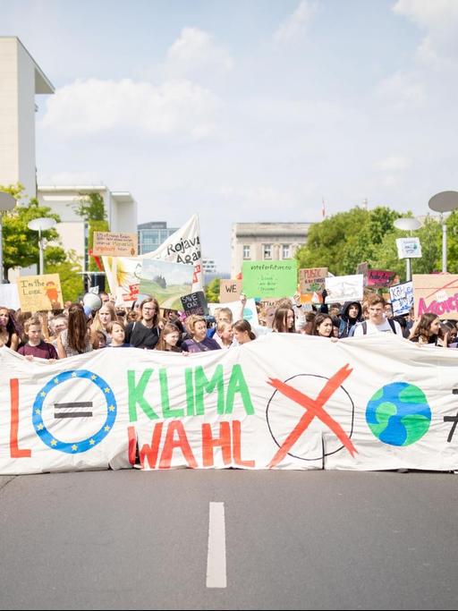 Im Vordergrund Schülerinnen und Schüler die einen großen Banner mit der Aufschrift "EU Wahl gleich Klimawahl" tragen. Im Hintergrund unzählige Schülerinnen und Schüler mit Transparenten.