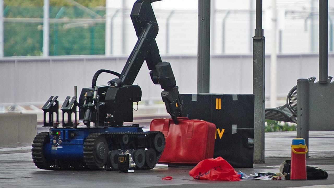 Ein ferngesteuerter Roboter zur Bombenentschärfung hebt am 08.10.2016 auf einem Gleis im Hauptbahnhof in Chemnitz (Sachsen) einen roten Koffer an. 