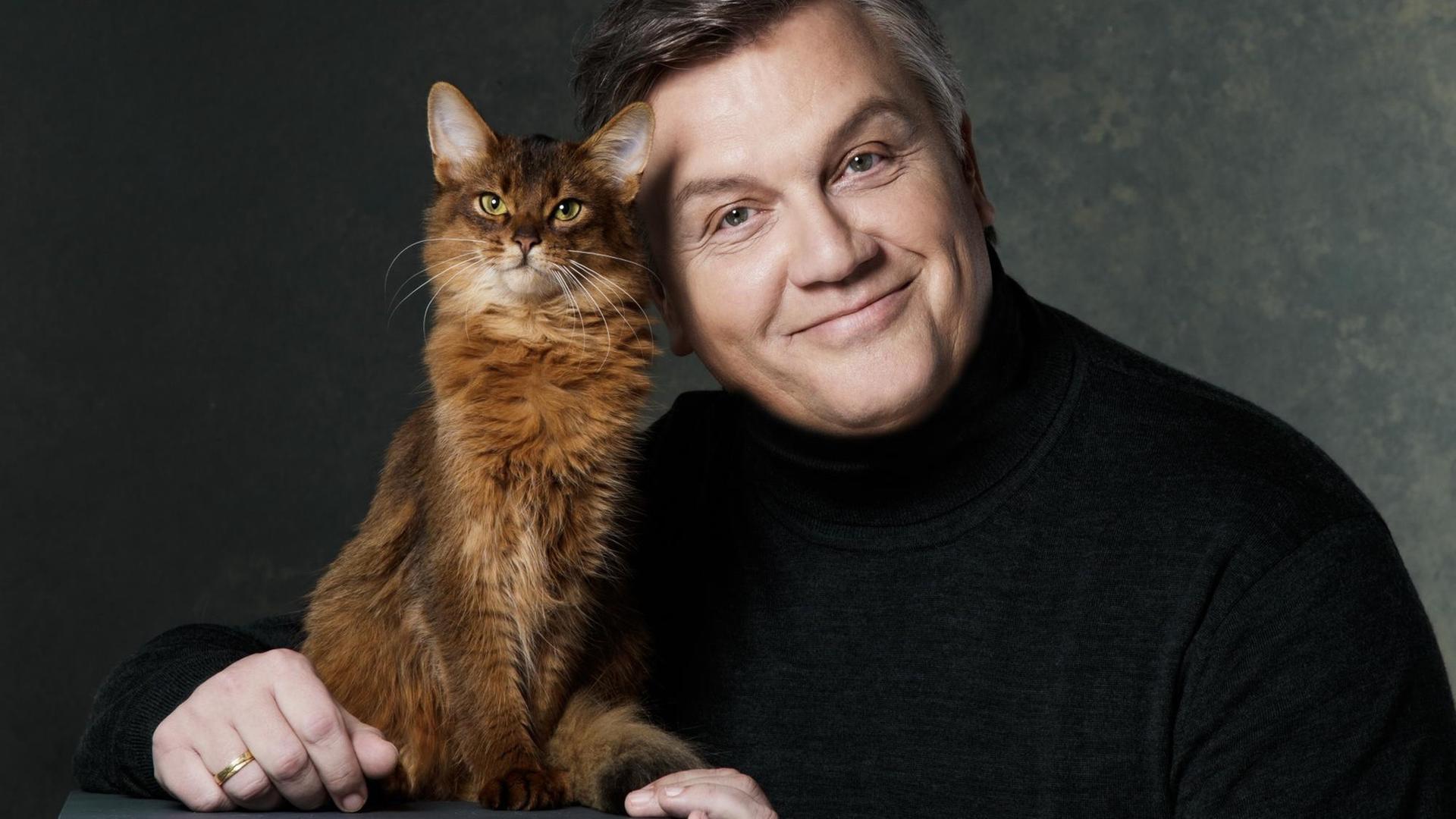 Komiker Hape Kerkeling schmust mit einer Katze.