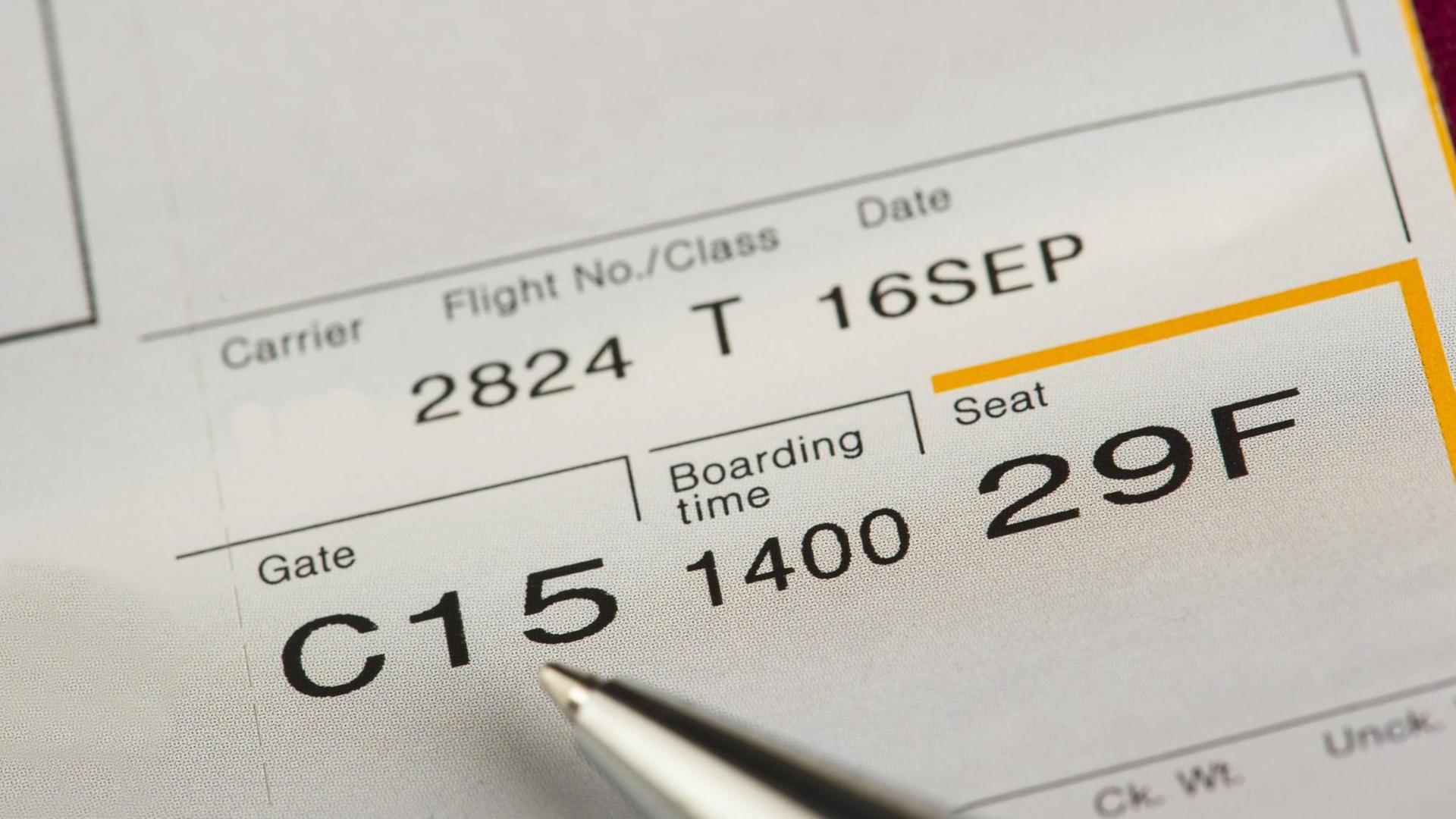 Ein Flugticket, auf dem das Datum, die Flugnummer, die Sitzplatznummer, die Boarding Time und die Gate-Nummer zu sehen sind.