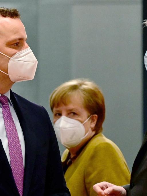 Bundesgesundheitsminister Jens Spahn (CDU) und Bundesinnenminister Horst Seehofer (CSU) sprechen vor der wöchentlichen Kabinettssitzung miteinander, während Bundeskanzlerin Angela Merkel an ihnen vorbeigeht.