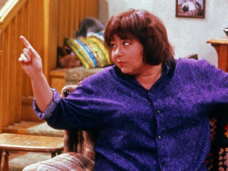 Die Darstellerin Roseanne Barr sitzt 1988 in einer Szene der Comedyserie "Roseanne" auf dem Sofa.