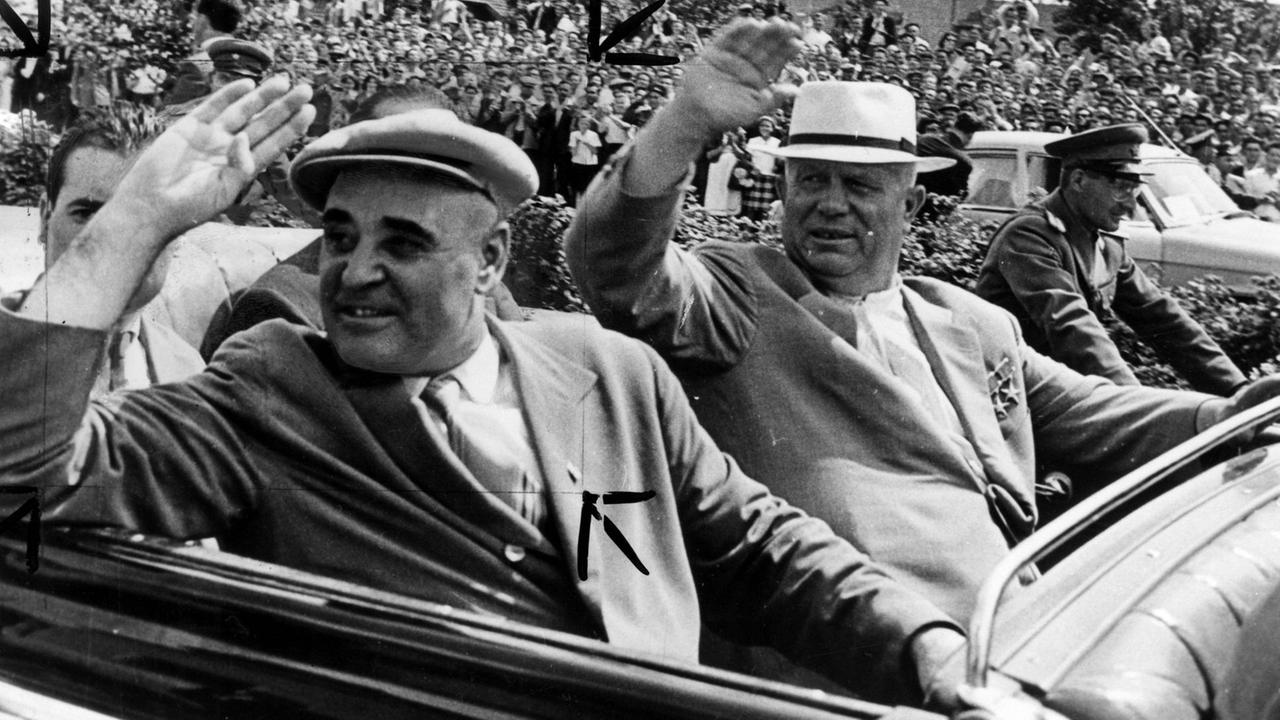 Rumäniens Machthaber Gheorghe Gheorghiu-Dej (links) fährt mit dem sowjetischen Regierungschef Nikita Chruschtschow in einem offenen Wagen durch Bukarest und winkt