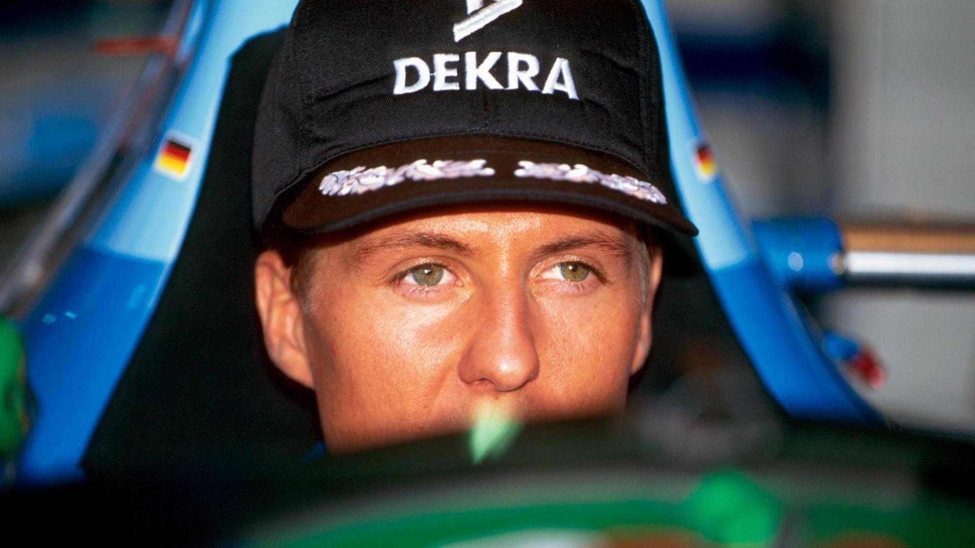 Das Bild zeigt Michael Schumacher mit schwarzem "Dekra"-Käppi im Cockpit seines Benetton-Rennwagens.