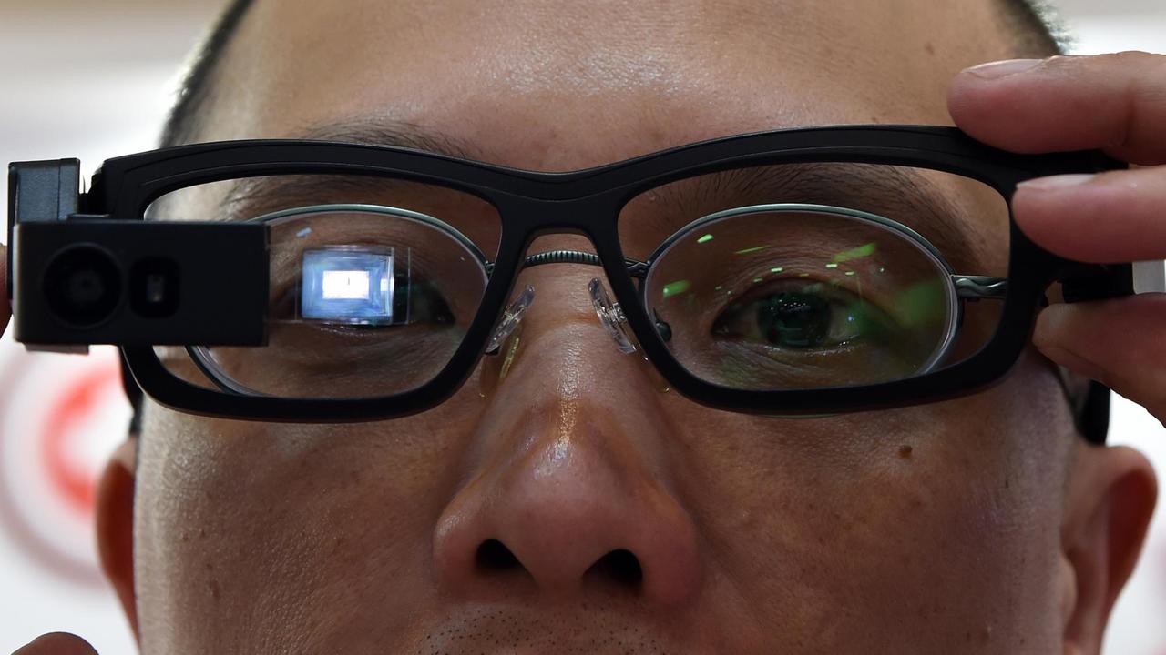 Elektronikmessebesucher trägt einen Miniaturcomputer in Form einer Brille