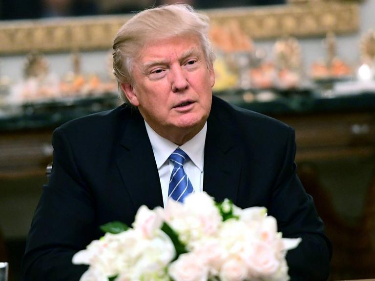 Trump sitzt an einem Tisch im Dining Room des Weißen Hauses