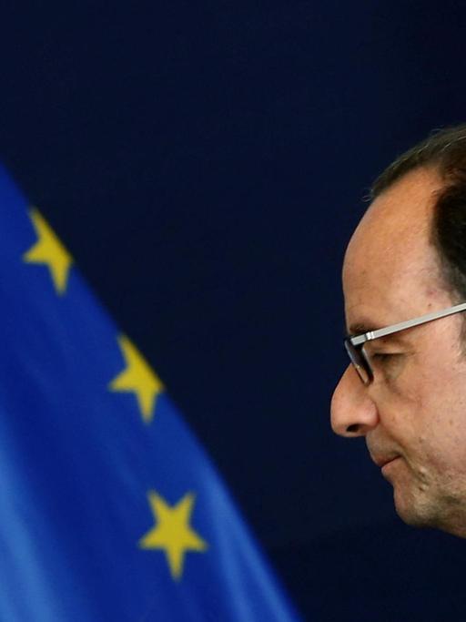 Der französische Präsident François Hollande neben einer EU-Flagge.