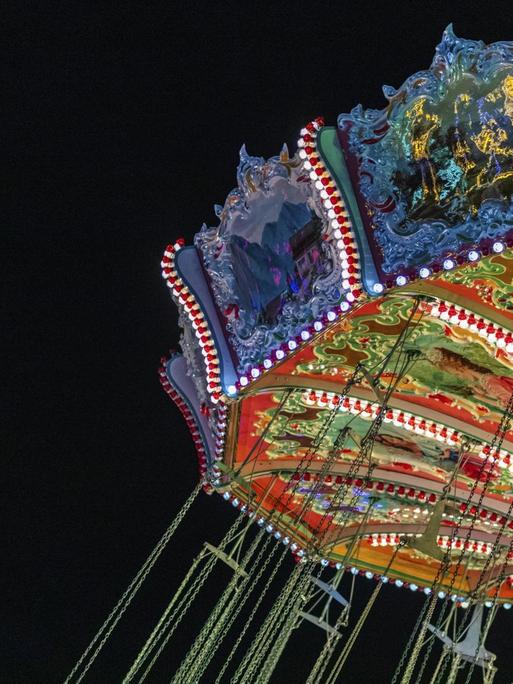 Kettenkarussell in München im nostalgischen Stil erleuchtet.