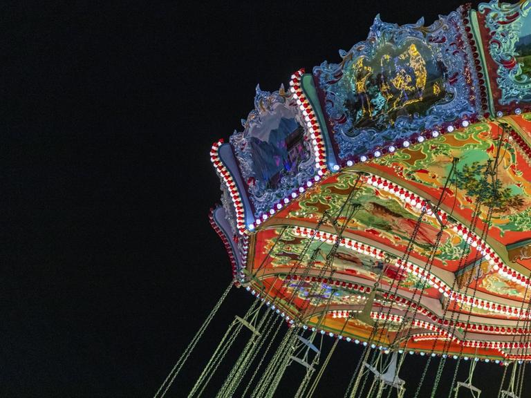 Kettenkarussell in München im nostalgischen Stil erleuchtet.