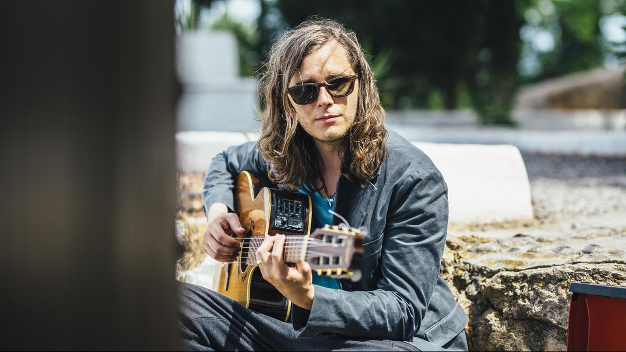 Der Kölner Musiker Kai Otten mit Sonnenbrille und Gitarre
