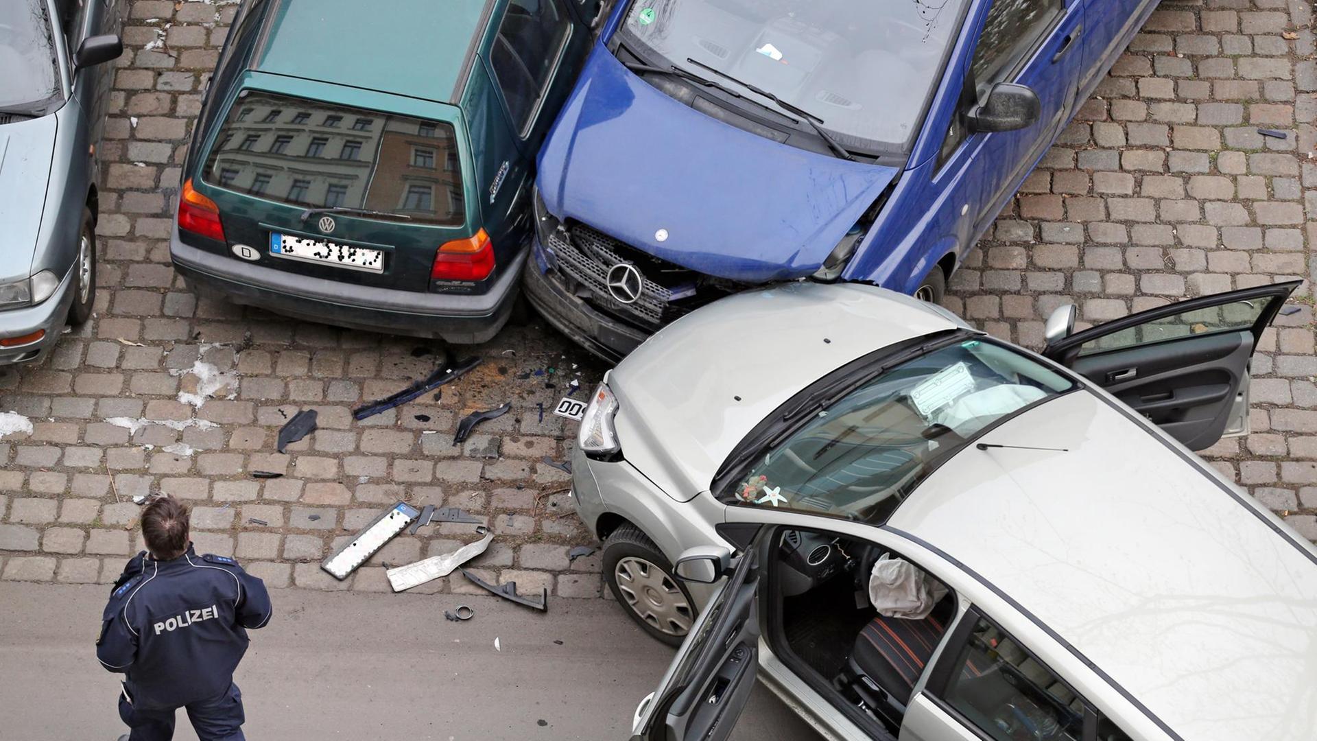 Ein Polizist nimmt am 29.01.2014 einen Verkehrsunfall an dem ein Ford Focus, ein VW Golf 3 und ein Mercedes Transporter Viano beteiligt sind in Leipzig (Sachsen) auf. Foto: Jan Woitas | Verwendung weltweit