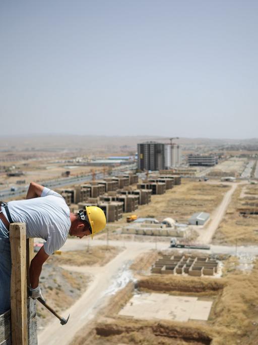 Ein Bauarbeiter auf einem Gebäude: Die Hauptstadt der autonomen Region Irakisch-Kurdistan, Erbil, wächst zunhemend
