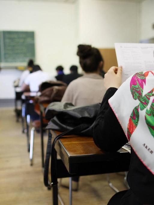 Schülerin mit Kopftuch in einer Schulklasse in Deutschland