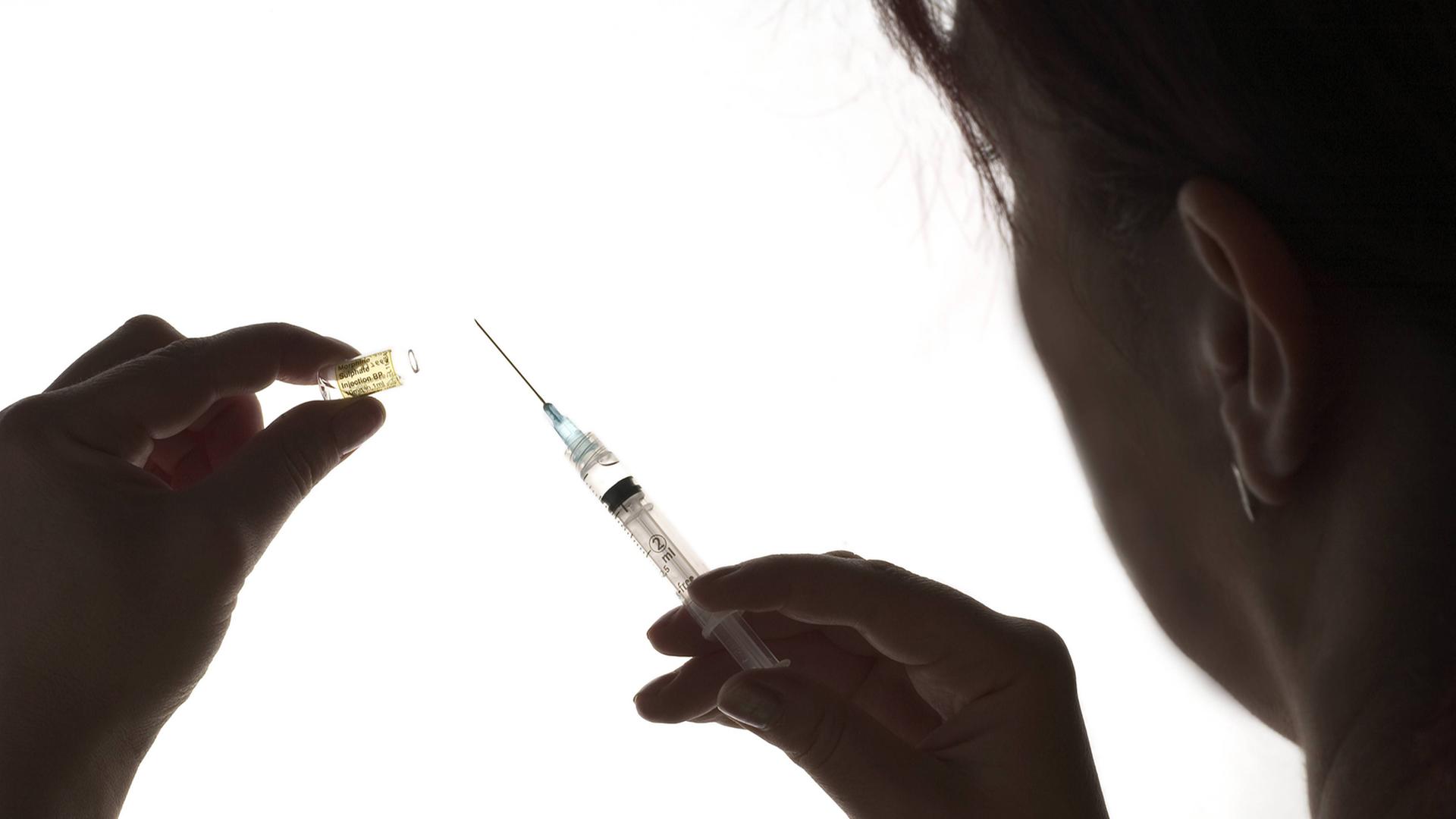 Eine Ärztin hält eine Spritze mit einem Opiod fest.