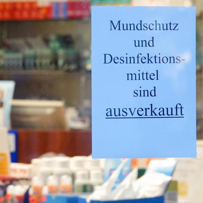 Ein Schild mit der Aufschrift Mundschutz und Desinfektionsmittel sind ausverkauft hängt im Fenster einer Apotheke.