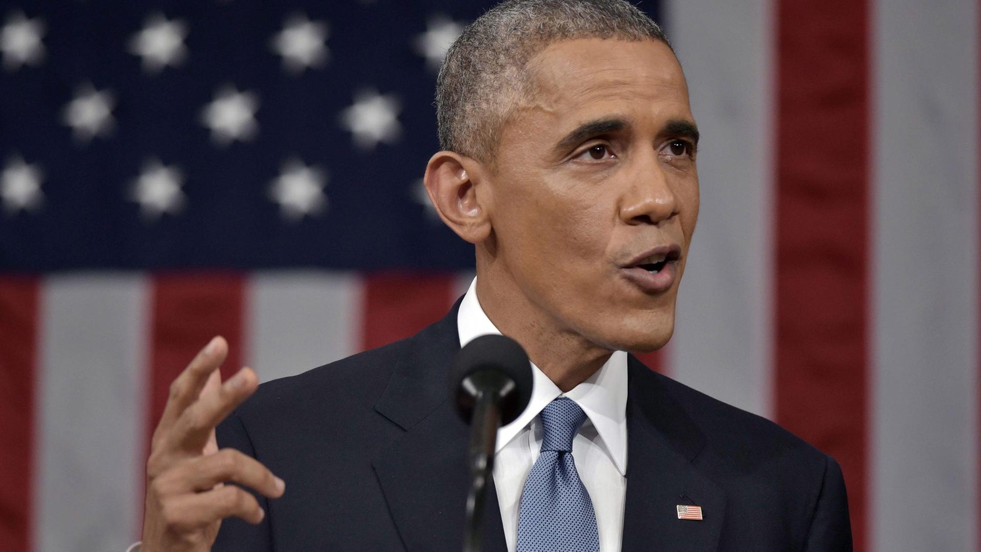 Obama gestikuliert bei seiner Rede, im Hintergrund die US-Flagge.