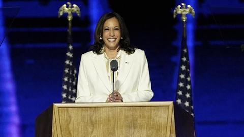 Kamala Harris lächelnd am Rednerpult.