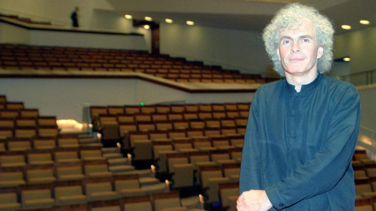 Sir Simon Rattle vor den leeren Rängen der Philharmonie in Berlin 2001.