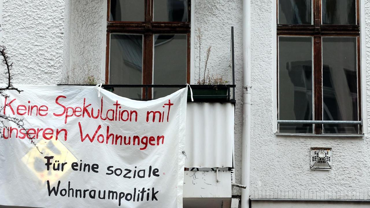 Ein Transparent gegen Wohnungsspekulationen hängt an einer Fassade eines Mietshauses im Berliner Bezirk Friedrichshain.