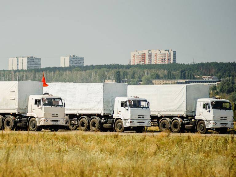 Drei Lastwagen des russischen Konvois für die Ost-Ukraine warten am 13.08.14 in der Nähe der Stadt Woronesch, etwa 400 Kilometer von Moskau entfernt.