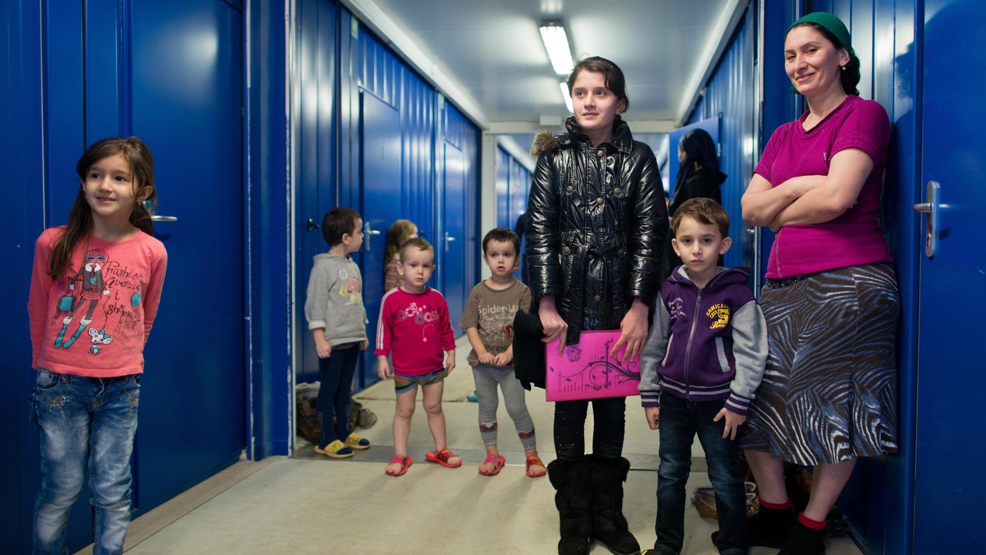 Eine Frau und viele Kinder aus Tschetschenien stehen am 26.02.2013 in einem Wohncontainer auf dem Gelände der Zentralen Ausländerbehörde des Landes Brandenburg in Eisenhüttenstadt (Brandenburg).