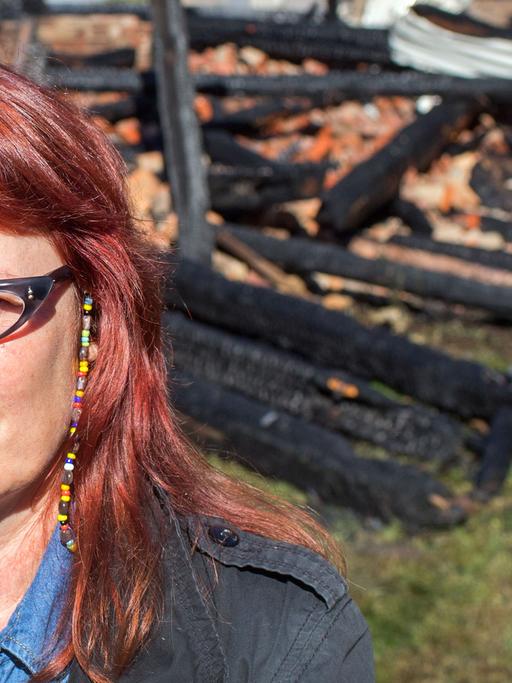Birgit Lohmeyer steht am 13. August 2015 vor den Resten ihrer verbrannten Scheune in Jamel.