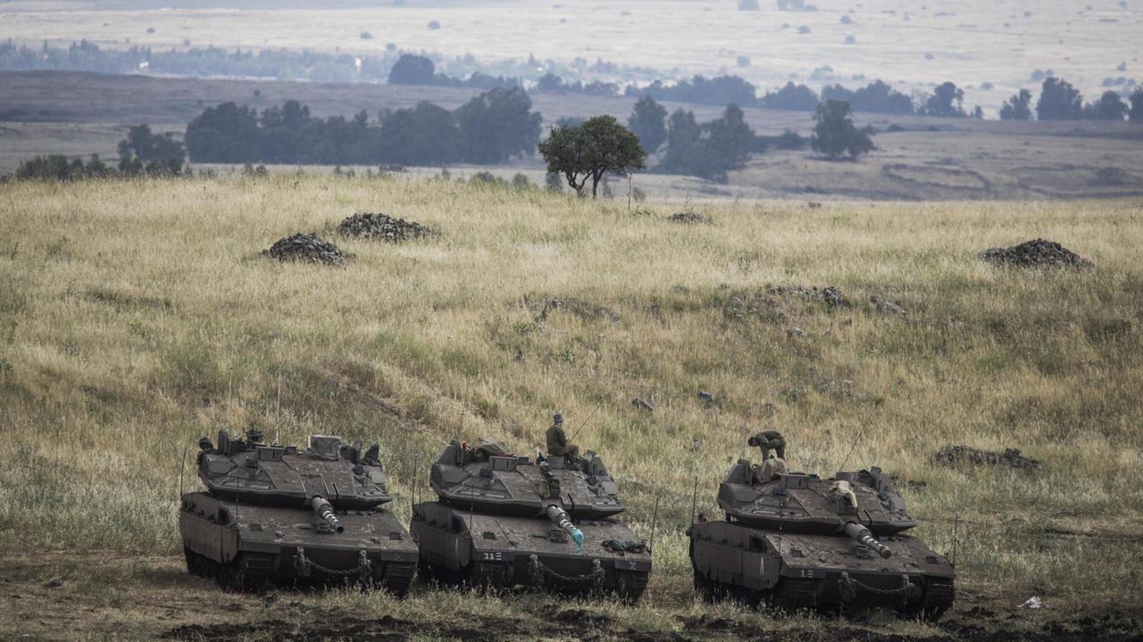 Israel, Golanhöhen: Israelische Merkava Kampfpanzer sind nahe der syrischen Grenze positioniert.