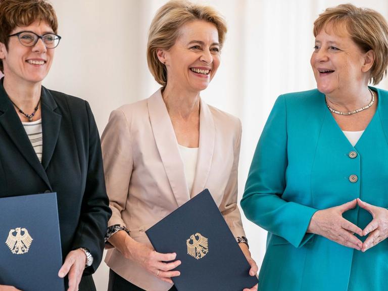 Ursula von der Leyen (Mitte), scheidende Verteidigungsministerin und neugewählte EU-Kommissionspräsidentin, erhält im Schloss Bellevue ihre Entlassungsurkunde neben ihrer Nachfolgerin Annegret Kramp-Karrenbauer (links), im Beisein von Bundeskanzlerin Angela Merkel.