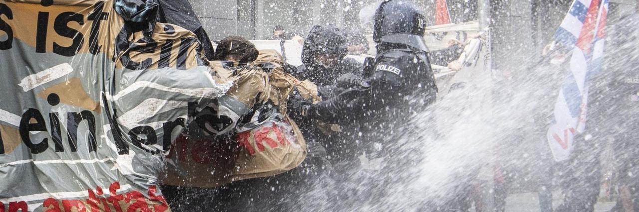 Polizei setzt einen Wasserwerfer auf die Gegner der "Querdenken"-Demonstration ein.

