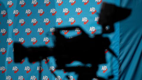 12.01.2019, Sachsen, Riesa: Eine Fernsehkamera steht bei der Europawahlversammlung der Alternative für Deutschland in der Sachsen-Arena. Im Hintergrund ist ein Banner mit AfD-Logos zu sehen.