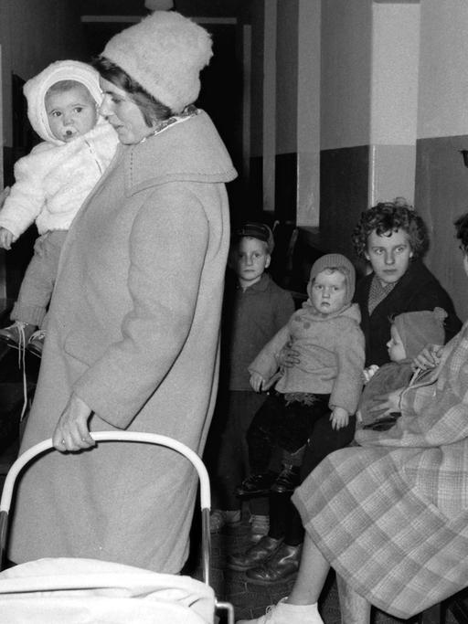 Einige aus der DDR geflüchtete Frauen und Kinder auf einem Flur.