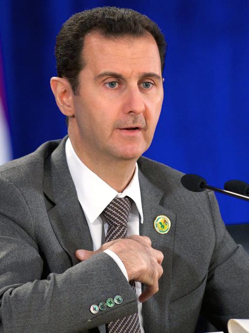 Syriens Präsident Assad spricht in ein Mikrofon.
