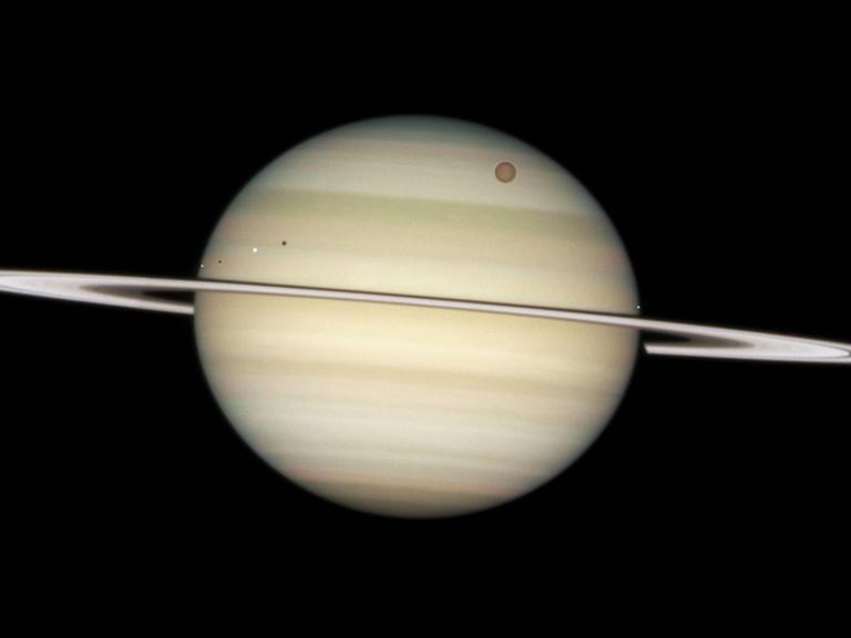 Der Saturn mit seinen Monden Encedalus, Dione, Titan und Mimas (v.l.n.r.)