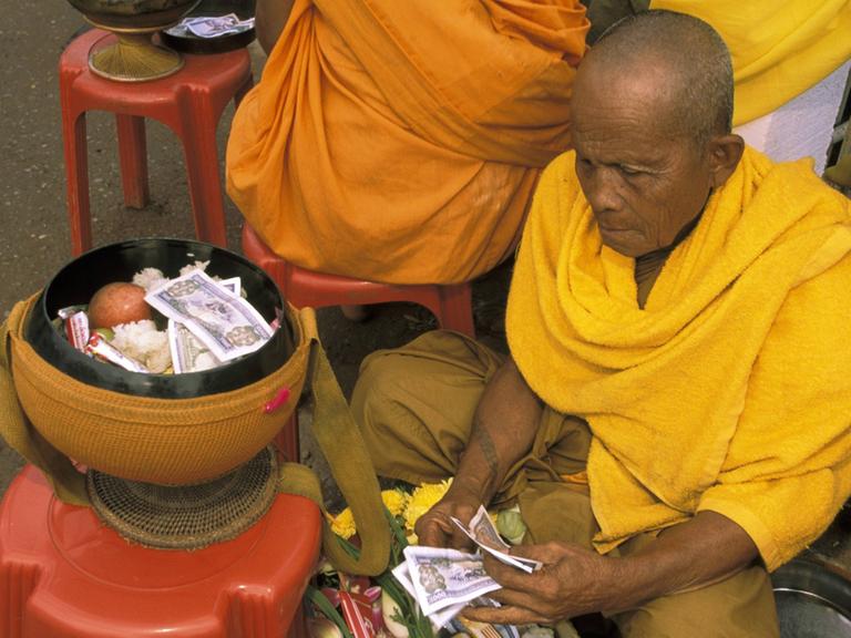 Spenden für die Mönche im Pha That Luang Temple in Vientiane.