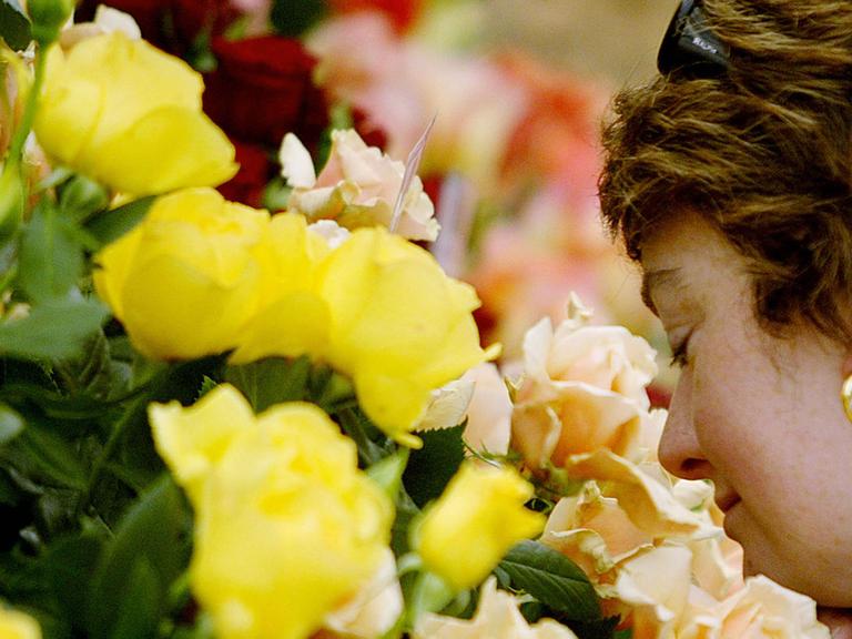 Eine Frau riecht an einem Blumenstrauß