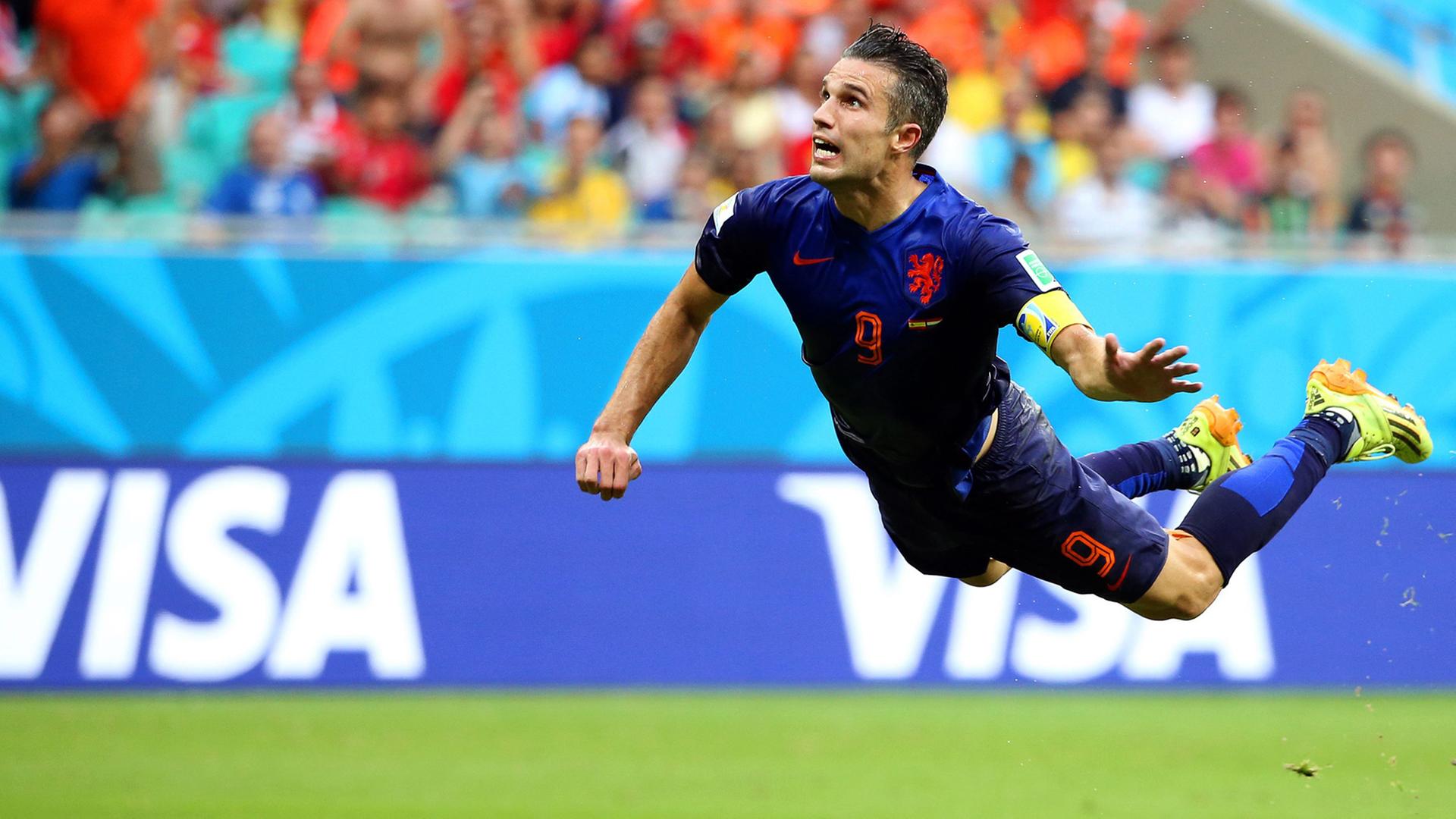 Der niederländische Spieler Robin van Persie springt hoch in die Luft zu einem Kopfball-Tor. Er liegt waagerecht in der Luft, es wirkt als ob er fliegt. Der niederländische Spieler Robin van Persie springt hoch in die Luft zu einem Kopfball-Tor. Er liegt waagerecht in der Luft, es wirkt als ob er fliegt.