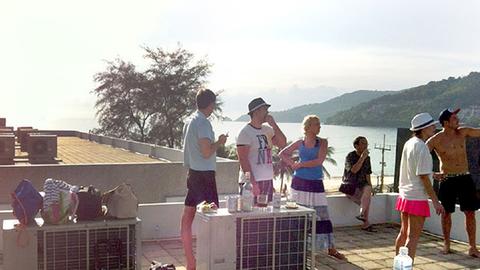 Australische Touristen stehen nach einer Tsunami-Warnung für die Region auf einem Hoteldach in Patong.